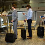 female staff checking boarding pass passengers check counter