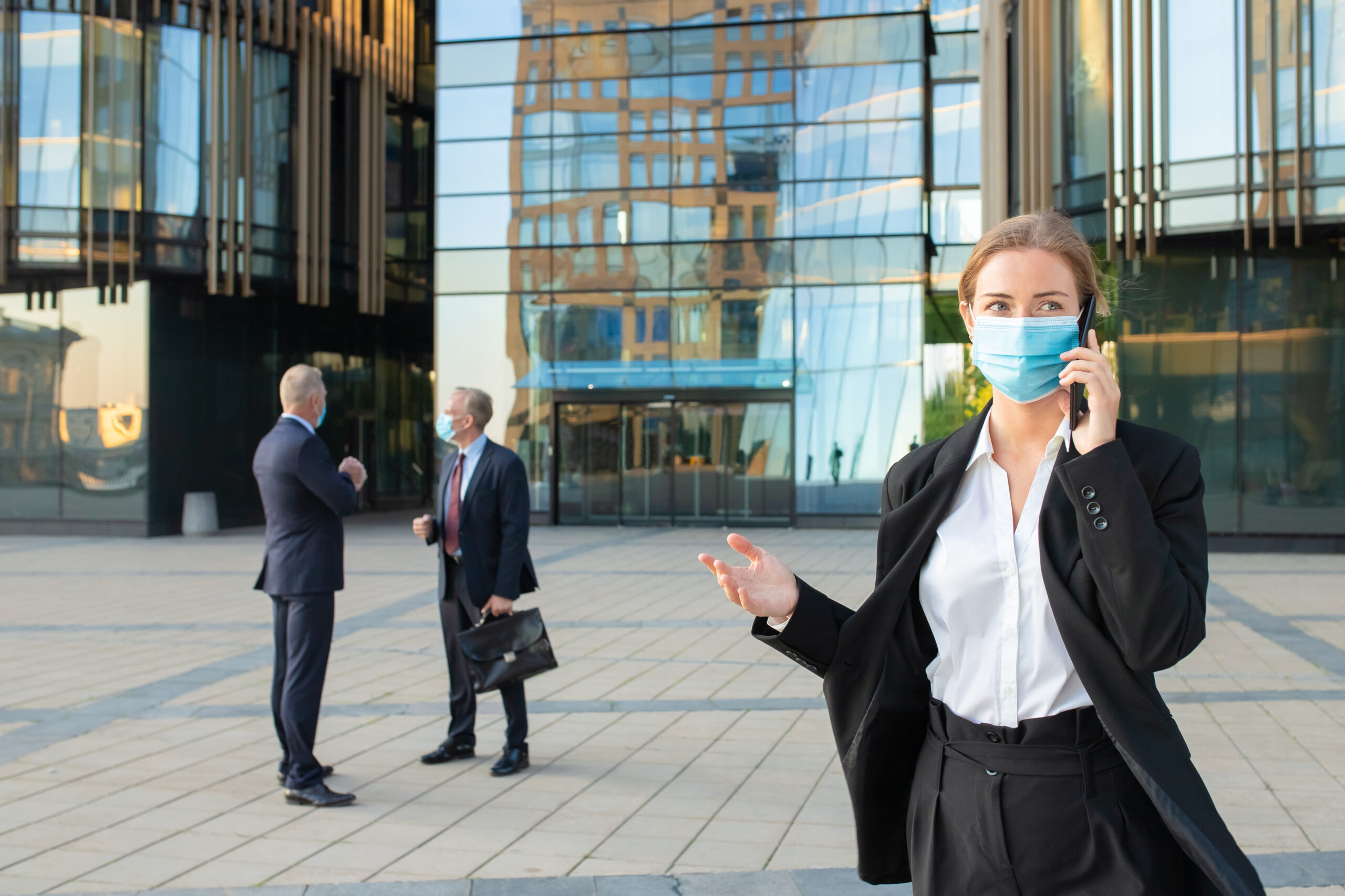 young business woman face mask office suit talking mobile phone outdoors businesspeople city buildings background copy space business epidemic concept 1 scaled